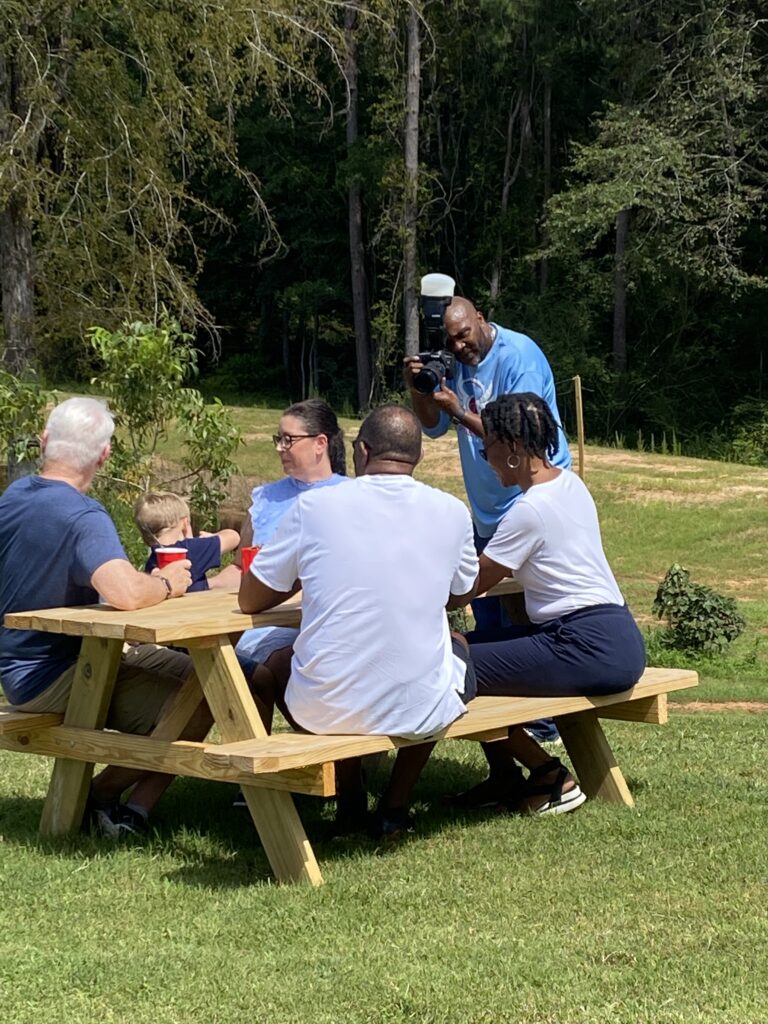 Guests gathered at picnic tables on the lawn during an event at Wandalands
