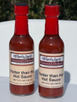 Two bottles of Wandaland’s Hotter Than Hot Hot Sauce with red caps.